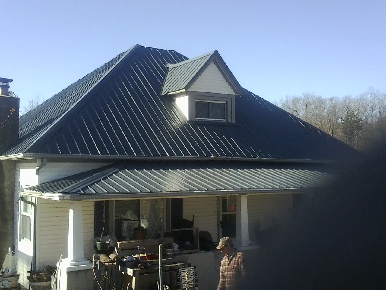 Dark blue standing seam metal roof with a dormer above a front porch in Chesterfield